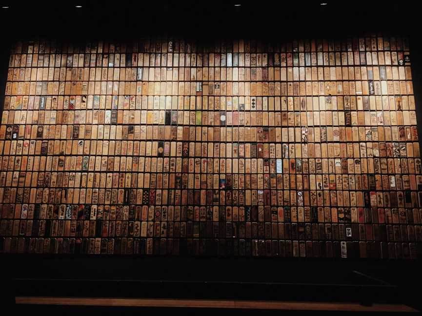 有一面掛滿了木牌的墻，上面的圖案都來自這裡演出者的手繪。